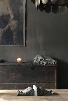 a table with a candle on it next to a painting and some other items in front of it