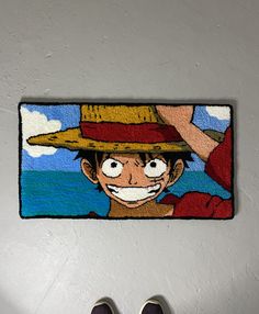 a person standing in front of a door mat with an image of one piece of the same character on it