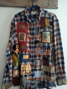 a shirt that is hanging up on a wall with some patches and other things attached to it