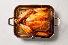 a roasting pan with a whole chicken on it