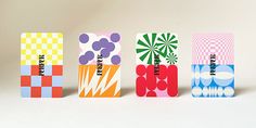 four different colored boxes with designs on them sitting in front of a white background,