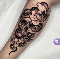 a black and white tattoo with a snake on it's arm, flowers in the background