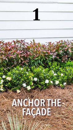 the number one sign in front of a house with flowers and bushes around it that says anchor the facade