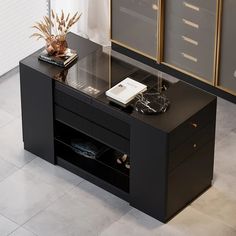 a black table with some books and a vase on it