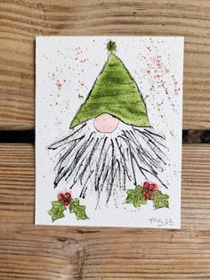 a handmade christmas card with an elf's hat and holly leaves on it