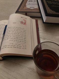 an open book next to a glass of tea