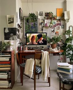 a desk with a television on top of it next to a wall full of books