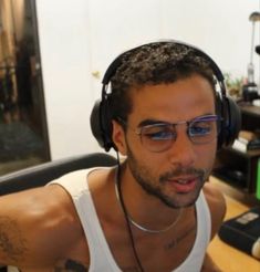 a man wearing headphones sitting in front of a computer