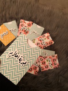 four tags with arabic writing on them sitting on a furnishing area next to a rug