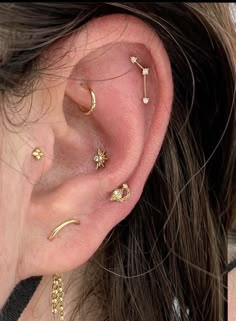 a woman's ear with three different piercings