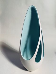 a white and blue vase sitting on top of a table