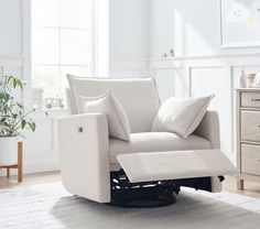 a living room with a white chair and pillows on the back of it's seat