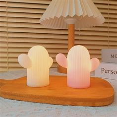 two cactus shaped lamps sitting on top of a wooden table