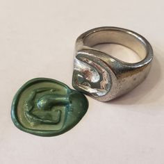 a ring sitting next to a wax stamp