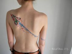 the back of a woman's body with tattoos on it