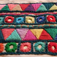 multicolored crocheted rugs are arranged on top of each other