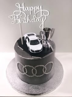 a birthday cake with a car and trophy on top