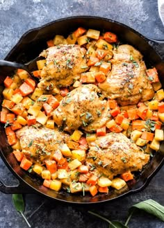 chicken, potatoes and carrots in a cast iron skillet