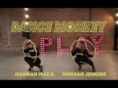 two people dancing in front of a neon sign with the words dance monkeyy play