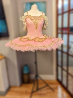 A pink and gold tutu with lace sleeves  pancake tutu. It one piece  tutu with 9 layers of stiff tulle. The bodice is a jacquard pink fabric and has a hook and eye fastening back, with 2 rows, for adjusting.  The skirt does have a flexible hoop. The pink colour is akin to a bubblegum pink.  Please send in measurements..we will make it for you. All tutus are made in conjunction with my Chinese production partner and are delivered directly from China.All costumes now include the shipping price of £ Pink Ballet Dress, Pancake Tutu, Burlesque Outfit, Girls Corset, Gold Tutu, Ballet Inspiration, Ballet Photos, Ballet Tutu, Beautiful Costumes