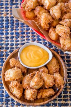 two bowls filled with fried food next to each other on a blue and white tablecloth