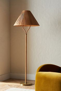 a lamp that is on top of a table next to a chair in a room