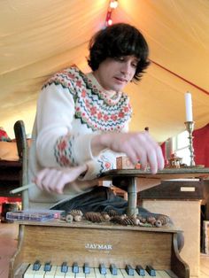 a young man playing an old fashioned piano