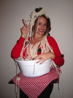 a woman in a red shirt is holding a bowl with noodles on it