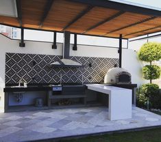 an outdoor kitchen with grill, sink and oven