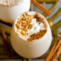 two glasses filled with milk and cinnamon on a table