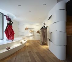 a woman's dress and shoes are on display in a store with wooden floors