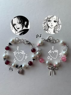 two bracelets with charms on them sitting next to each other