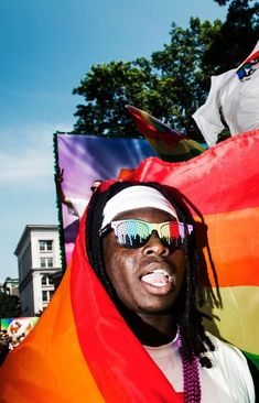 a man with sunglasses and a rainbow flag