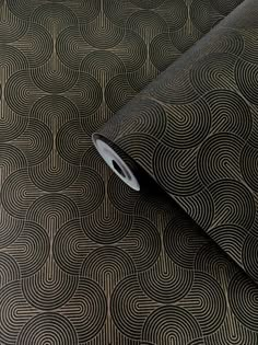 a roll of black and gold wallpaper with an abstract design on the bottom half