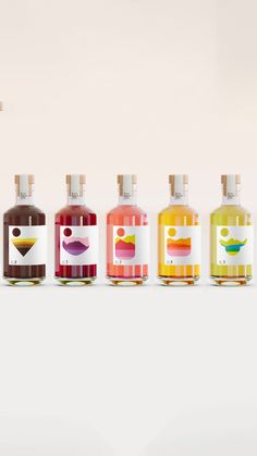 six bottles of liquid are lined up against a white background, each containing different colors