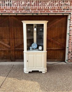 a white cabinet sitting in front of a garage door