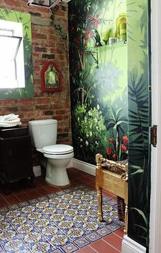 a bathroom with a brick wall and painted mural on the walls, along with a toilet