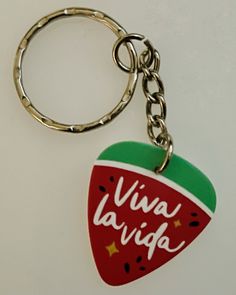 a strawberry shaped keychain with the words viva la vieja written on it