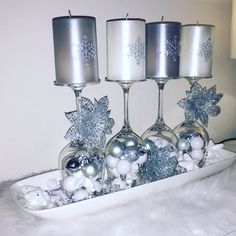 three wine glasses are sitting on a tray with silver ornaments and snowflakes in them