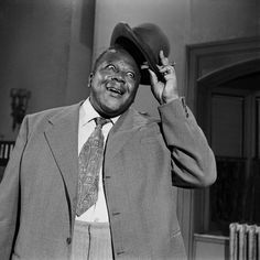 a man in a suit and tie holding a hat