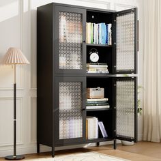 a bookcase with many books in it next to a lamp