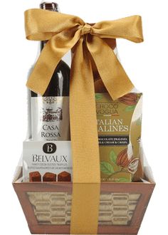 a bottle of wine and chocolates in a gift basket with a bow on the top