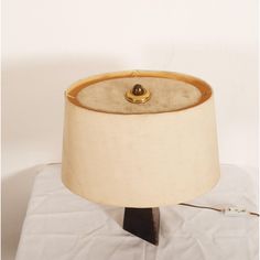 a lamp that is sitting on top of a white table cloth with a black base