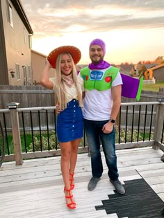 a man and woman dressed up as buzz lightyear from toy story land standing on a deck