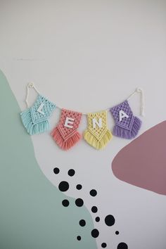 three crocheted letters are hung on a string with tassels that spell out the word love