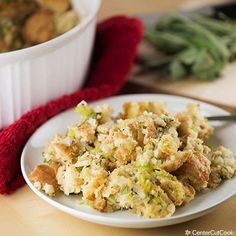 a white plate topped with stuffing next to a bowl of green beans