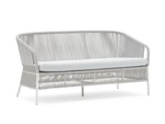 a white wicker couch with a cushion on the back and armrests, in front of a white background