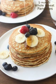 pancakes with bananas and blueberries are stacked on top of each other, ready to be eaten