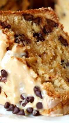 a close up of a piece of cake on a plate with chocolate chips and frosting