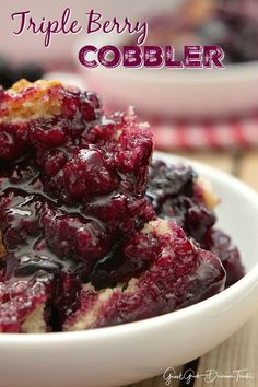 a white bowl filled with blueberry cobbler on top of a wooden table